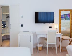 a living room with a white table and a tv at Hotel Mainè in Finale Ligure