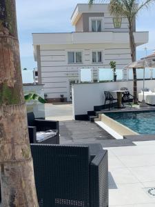 una piscina con mesa y sillas junto a un edificio en Hotel Elite, en Varcaturo