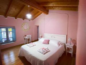 1 dormitorio con 1 cama blanca y paredes rosas en B&B Su Strintu, en Tuili