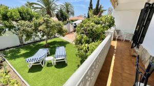 balkon z 2 krzesłami i trawnikiem w obiekcie Chalet en primera Línea con 150m2 de Jardín Privado w mieście Torrox Costa