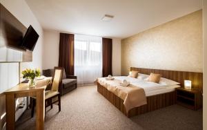 um quarto de hotel com uma cama e uma secretária em ROYAL M em Sabinov