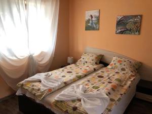 a bed sitting in a bedroom with a window at Къща за гости Симона яз.Тича in Sushina