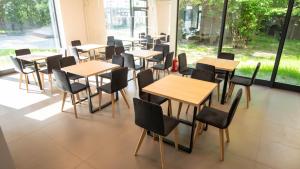 a row of tables and chairs in a room with windows at Nowe Millenium in Świnoujście