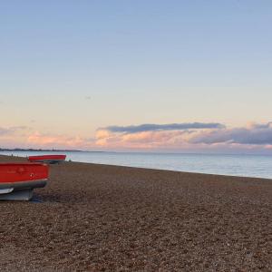 a red car parked on a beach near the water at Argyll House Bed and Breakfast in Westleton