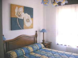 a bedroom with a bed and a picture of flowers at Residencial Cilla - 6022 in Noja +9 photos