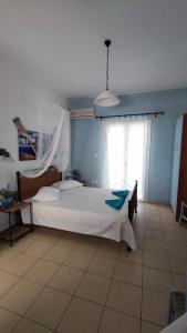 a bedroom with a large white bed and a window at kamares kythnos in Kanala +16 photos