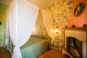 a bedroom with a bed and a fireplace at Casale Villa Giulia Marina di Lesina in Lesina