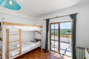 sypialnia z łóżkiem piętrowym i balkonem w obiekcie Boa Vida Guest House w Aljezur