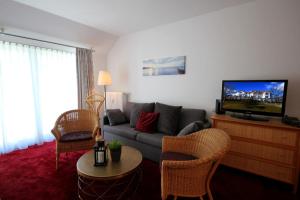 ein Wohnzimmer mit einem Sofa und einem TV in der Unterkunft Villa Bellevue Premium by Rujana in Binz