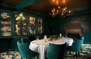 a dining room with a table and chairs and a chandelier at Fonab Castle Hotel in Pitlochry