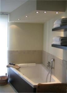 a bathroom with a bath tub with towels in it at Landhaus Glowe in Glowe