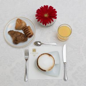 a table with a plate of food and a cup of coffee at Hotel Vienna Ostenda e Ristorante il Danubio in Rimini