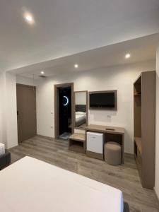 a hotel room with a bed and a tv and a bedroom at Hotel Mare 2 in Ksamil