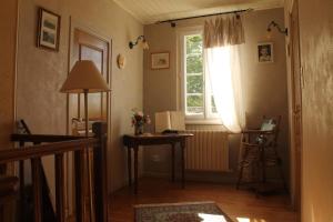 Habitación con ventana y mesa con lámpara. en Maison d'Hôtes Las Baillargues de Haut, en Mouchan