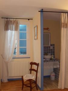 a bathroom with a window and a chair and a sink at Maison d'Hôtes Las Baillargues de Haut in Mouchan