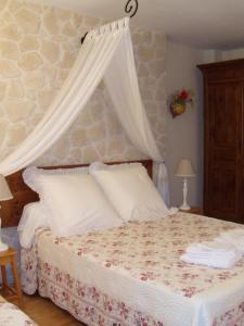 a bedroom with a bed with a canopy at Maison d'Hôtes Las Baillargues de Haut in Mouchan