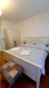 a white bed with two towels on top of it at Apartament Piasek i Morze in Rowy