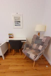 a living room with a chair and a desk at Apartament Piasek i Morze in Rowy