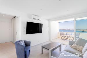 - un salon avec une télévision, un canapé et une table dans l'établissement Sea view 3 bedroom with AC and parking - Dodo et Tartine, à Toulon