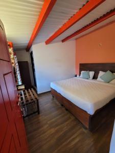 ein Schlafzimmer mit einem großen Bett in einem Zimmer in der Unterkunft REFLECTIONS Guest House in Udagamandalam