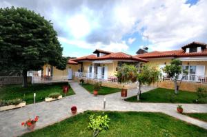 a large house with a patio and a yard at EXOHI STUDIOS in Sarti