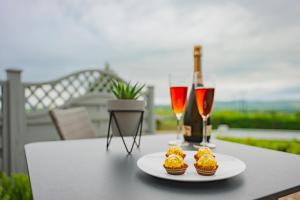 two cupcakes and two glasses of wine on a table at Beau Vista Lodge in Dunnamanagh