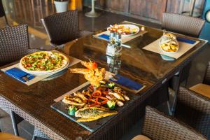 a table with two plates of food and two pizzas at Apartments Horizont in Budva