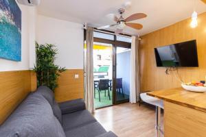 Una sala de estar con un sofá y un televisor de pantalla plana. en Sand Friendly Holiday Home, en Playa del Inglés