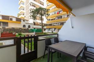 Un balcón con una mesa y sillas y un edificio. en Sand Friendly Holiday Home, en Playa del Inglés
