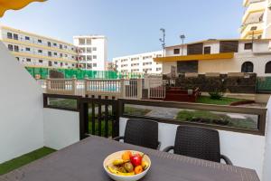 Un bol de fruta en una mesa en un balcón. en Sand Friendly Holiday Home, en Playa del Inglés