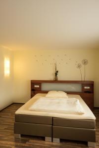 Hotel Viola في هوتشهيم ام ماين: غرفة نوم مع سرير كبير مع طيور على الحائط