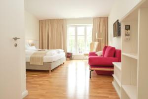 a bedroom with a bed and a red couch at Domizil Gols, Boutique - Hotel in Gols +79 photos