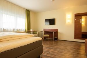 una camera d'albergo con letto e scrivania di Hotel Viola a Hochheim am Main