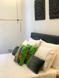 uma cama com lençóis brancos e almofadas em F.T.P Luxury Rooms em Patra