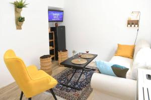 sala de estar con sofá, mesa y sillas amarillas en La CaSita, en Vara de Rey