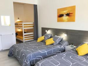 a bedroom with two beds with yellow pillows at Appartement Le Solea 100m2 climatisé parking proche Sanctuaires in Lourdes