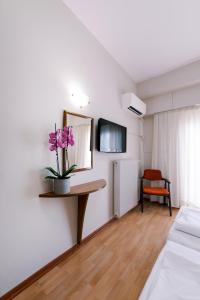 a room with a table with a plant on it at Hotel Cronos in Arta