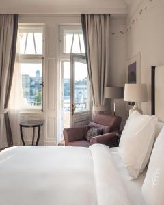 1 dormitorio con 1 cama, 1 silla y 1 ventana en Four Seasons Hotel Gresham Palace Budapest en Budapest