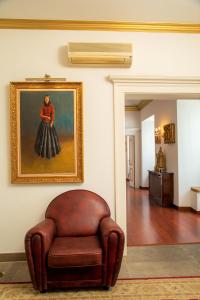 a brown leather chair sitting in a room with a painting at Casa Senhoras Rainhas - Óbidos - by Unlock Hotels in Óbidos