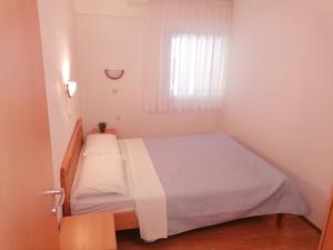 Habitación blanca pequeña con cama y ventana en Apartman Bruna, en Novigrad Istria