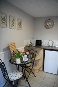 
a kitchen with a table and chairs and a refrigerator at Fern Cottage in St Ives
