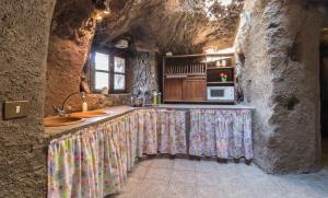 a kitchen with a counter in a stone wall at Casa Cueva Las Margaritas in Artenara