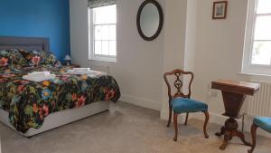 a bedroom with a bed and a table and a chair at Argyll House Bed and Breakfast in Westleton