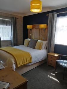 a bedroom with a large bed with a yellow blanket at Park Top House in Haworth