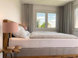 巴特弗斯勞的住宿－Haderer's Home - Bad Vöslau near Vienna，卧室配有白色的床和2扇窗户。