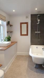 a bathroom with a tub and a sink and a toilet at Argyll House Bed and Breakfast in Westleton