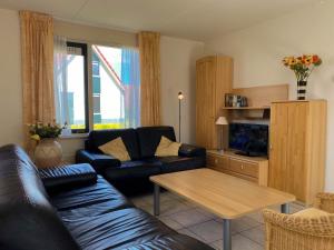sala de estar con sofá y mesa en Hello Zeeland - Vakantiehuis Stern 265, en Breskens