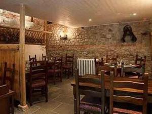 a restaurant with wooden tables and chairs and a brick wall at The Lamb Inn in Marlborough