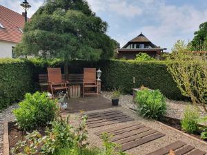 un jardín con 2 sillas y una terraza de madera en Ferienwohnung Sonnenschein, en Sagard
