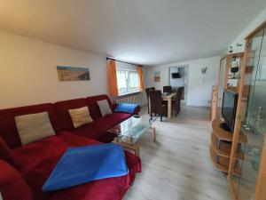 a living room with a red couch and a table at Ferienwohnung Sonnenschein in Sagard